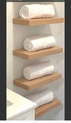 three shelves with towels on them in a bathroom