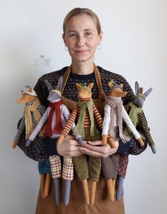 a woman holding several stuffed animals in her hands