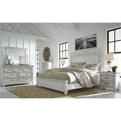 a bedroom with white furniture and large windows