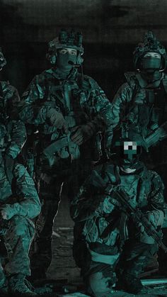 a group of soldiers standing next to each other in the dark with their arms around one another