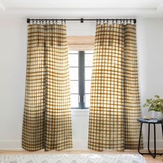 the curtains are hanging in front of a window with a white and yellow checkerboard pattern