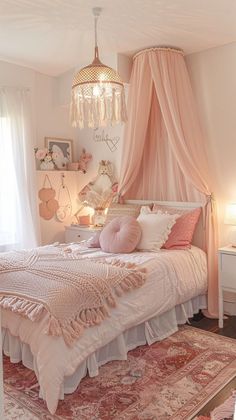 a bedroom with a pink canopy bed and chandelier hanging from it's ceiling