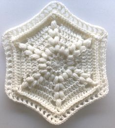 a white crocheted square on top of a table