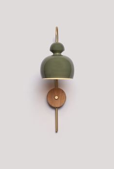 a green wall light with a wooden base