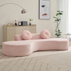 a pink couch sitting on top of a rug in a living room