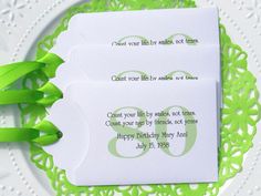 two cards with green ribbons are on a doily