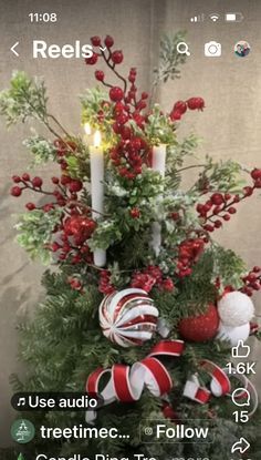 a christmas tree decorated with candy canes and greenery is displayed on the phone screen