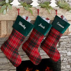 three christmas stockings hanging from a fireplace with the word personalized on them and an open fire