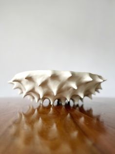 a white sculpture sitting on top of a wooden table