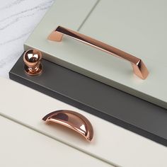 a close up of a door handle on a white and grey cabinet with pink handles