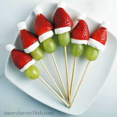 the cover of grin fruit kabobs on a plate with strawberries and grapes