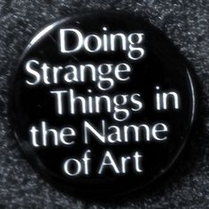 a black button with the words doing strange things in the name of art