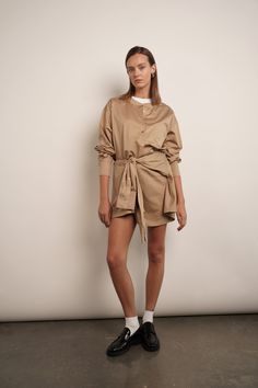 The Sierra shirt dress is effortlessly chic. It's made from crisp cotton-poplin with a loosely draped top and close-fitting mini skirt. Unbutton the collar to create a more relaxed look. Dress is designed to look like a deconstructed shirt worn back to front. Detailed with buttons along the reverse, it's cut from cotton-poplin and has a loose shape tempered by ties at the waist meant to resemble a second pair of sleeves. 100% Cotton Collared Mini Dress For Daywear With Belt, Chic Cotton Dresses With Shirttail Hem, Relaxed Fit Shirt Dress For Spring Workwear, Beige Mini Shirt Dress For Work, Beige Mini Length Shirt Dress For Work, Chic Relaxed Fit Shirt Dress For Fall, Relaxed Fit Mini Shirt Dress For Work, Relaxed Fit Mini Length Shirt Dress For Daywear, Chic Fall Shirt Dress With Shirttail Hem