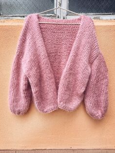 a pink sweater hanging on a clothes line