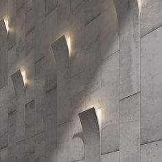 the light shines on the side of a wall with curved concrete columns and arches