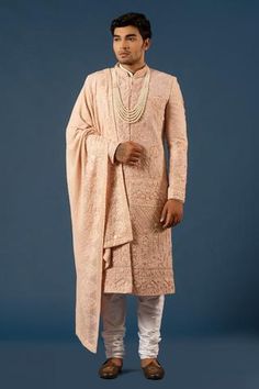 Pink sherwani in raw silk base with hand embroidered floral motifs. Paired with an off-white churidar. Comes with layered beaded mala and embroidered stole.
Component: 4
Pattern: Embroidered
Type Of Work: Floral Motifs
Neckline: Mandarin
Sleeve Type: Straight Full
Fabric: Raw Silk
Color: Pink
Other Details: 
Side slit sherwani
Note: The inner white kurta worn by the model is not for sale
Occasion: Groom - Aza Fashions Pink Sherwani, White Churidar, Embroidered Sherwani, Mens Wear Wedding, Wedding Outfits For Groom, Sherwani Groom, Mens Sherwani, Wedding Sherwani, White Kurta