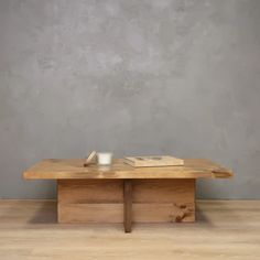 a wooden table with a book on it and a cup sitting on top of it