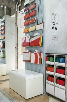 a room with several shelves and bins on the wall, some holding folders