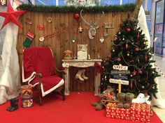 a room decorated for christmas with presents and decorations on the wall, including a chair