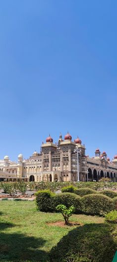 a large building with lots of windows on top of it's sides and green grass in the foreground