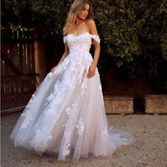 a woman in a white wedding dress standing outside