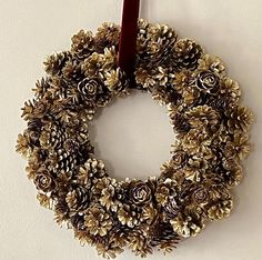 a pine cone wreath hanging on the wall