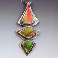 Three Stone Ammolite Totem Pendant In A Sterling Silver Setting. Flashes From Orange To Green. Accent Stone Set At Top One Of A Kind Multicolor Fusion Jewelry, Metalwork Jewelry, Modernist Jewelry, Polymer Crafts, Beach Boho, Stone Settings, Three Stone, Green Orange, Green And Orange