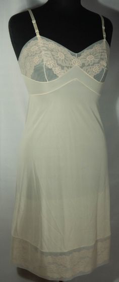 "Here's a late 60s/early 70s made in U.S.A. off white cream color slip dress that is in great condition with the iconic Vanity Fair label. This slip has adjustable shoulder straps, fitted bodice top and skirt slip to the knee lower half that's trimmed in lace. Perfect! The original Vanity Fair label says it's a size 32 and laid-flat measurements are included here for you to check the fit - it seems tiny! This is a lovely slip is a basic that's so versatile and makes a great vintage wardrobe stap Slip Dress Undergarment, 70s Slip Dress, Vintage Slip Skirt, Fitted Cream Camisole With Spaghetti Straps, White Fitted Sheer Camisole, White Sheer Fitted Camisole, White Sheer Slip Dress For Summer, Fitted Cream Camisole With Built-in Bra, Vintage Camisole With Built-in Bra For Summer