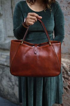 This handmade leather bag is made with 100% natural full grain leather which is tanned with all natural materials. There is no chemical materials in this leather.  This bag is handmade in our studio in Milan.  The lining is 100% cotton and it is easy to clean.  The bag has one middle divider which is a big zipped pocket. There is One smaller zipped pocket in one side and 2 small open pockets  All the bags will come with a cotton dust bag which can protect the leather and bag when it is not in us Elegant Satchel In Soft Vegetable Tanned Leather, Elegant Vegetable Tanned Leather Satchel Tote, Elegant Brown Shoulder Bag In Vegetable Tanned Leather, Elegant Everyday Shoulder Bag In Vegetable Tanned Leather, Elegant Vegetable Tanned Leather Satchel, Elegant Brown Vegetable Tanned Leather Shoulder Bag, Elegant Shoulder Bag With Smooth Grain Vegetable Tanned Leather, Elegant Vegetable Tanned Leather Tote Bag, Elegant Shoulder Bag In Vegetable Tanned Leather