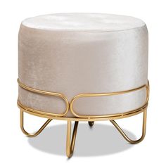 a white ottoman sitting on top of a metal stand with a gold frame around it