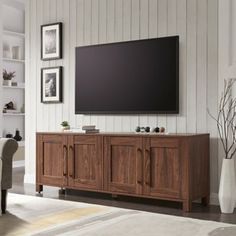 a large flat screen tv mounted to the side of a wooden cabinet in a living room