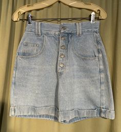 This is a pair of vintage jean shorts from the 80s. Labeled, No excuses, Tough Jeans, Femme Fatale, they are a labeled a size 7/8. Waist 26" Inseam 5.5", please see measurements below.  Made of light blue cotton denim. They have a metal button fly & metal button on the waistband. Waistband has double belt loops. The shorts are high waist, riveted pockets on the front hips along with a small watch pocket on the right side. The seat has 2 patch pockets. The legs are wide & cuffed.  The shorts are Vintage Mid-rise Bottoms With Built-in Shorts, Vintage Short Denim Blue Bottoms, Vintage High-waisted Medium Wash Jean Shorts, Vintage High-rise Blue Jean Shorts, Tomboy Jeans, Vintage Mid-rise Denim Blue Shorts, 80s Shorts, Vintage Jean Shorts, Jean Vintage