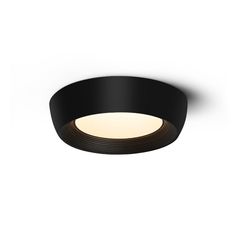 a black circular light fixture on a white wall