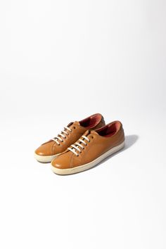 Salvatore Ferragamo cognac leather sneakers. Great condition. Size US 9 As these items are previously owned, we do not accept returns Brown Leather Lace-up Shoes With Perforated Toe Box, Brown Leather Cap Toe Shoes With Perforated Toe Box, Brown Casual Cap Toe Leather Shoes, Casual Brown Cap Toe Leather Shoes, Custom Casual Brown Sneakers With Plain Toe, Casual Brown Leather Shoes With Perforated Toe Box, Casual Leather Shoes With Cap Toe And Leather Sole, Casual Brown Custom Sneakers With Rubber Sole, Classic Brown Wingtip Sneakers