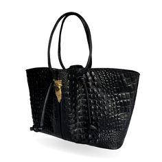 This tote bag is a statement piece that effortlessly elevates your style. Crafted from a glossy luxurious crocodile-textured leather, it offers a touch of sophistication and elegance.  Its spacious interior, complete with compartments and pockets, offers ample room for your daily essentials. The knotted strap is adjustable to any length, perfect for super comfortable shoulder wear and its closure consists in two golden clasps. Exterior: Bovine black leather with lizard texture Interior: cotton l High-end Leather Bag With Crocodile Pattern, Luxury Crocodile Pattern Shoulder Bag For Daily Use, Luxury Crocodile Pattern Shoulder Bag, Luxury Leather Bag With Crocodile Pattern, Luxury Crocodile Pattern Satchel For Everyday Use, Luxury Satchel With Crocodile Pattern Tote, Luxury Crocodile Pattern Shoulder Bag For Shopping, Luxury Bags With Crocodile Pattern For Daily Use, Luxury Crocodile Pattern Tote Satchel