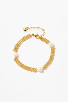 Adorn your wrist with a luxurious blend of woven gold strands and lustrous pearls, offering versatility and sophistication for every wearer. Gold Pearl Charm Chain Bracelet, Gold Metal Pearl Bracelet With Pearl Charm, Gold Pearl Bracelet With Metal Charm, Gold Pearl Bracelet With Chain, Gold Plated Pearl Chain Bracelet, Adjustable Gold Pearl Drop Bracelet, Elegant Adjustable Chain Bracelet With Pearl Charm, Adjustable Yellow Gold Bracelet With Pearl Chain, Elegant Adjustable Pearl Charm Chain Bracelet