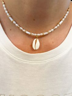 "Beautiful Cowrie Necklace  ✨Freshwater Pearls ✨ Gold-filled beads ✨24k Gold Plated Chain ✨Necklace Length : 14.5 \" + 1.5\" extension 💫 Allow 1- 3 business days for the production before shipping. 💫 All jewelry comes in a cute pouch for storage. 💫 This product is handcrafted and shipped from Palm Beach, FL." White Beaded Cowrie Shell Necklaces, Beachy Cowrie Shell Necklace, White Cowrie Shell Beachy Necklace, Handmade White Cowrie Shell Necklace, Unique White Cowrie Shell Necklace, Heishi Necklace, Cowrie Shell Necklace, Beach Necklaces, Necklace Chain Lengths