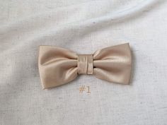 "We proudly present our premium handmade pre-tied bow tie for Adult/Men/Women/Kids/Children/Toddler/Baby boy/girl.... **The bow tie is pre tied and hand stitched into place.** Material: N/A Choose your Bow tie ATTACHMENT/STRAP: - CLIP-ON (strapless) - Adjustable VELCRO strap - Adjustable strap with METAL HOOK, EYE ADJUSTER HARDWARE SIZES are shown below: - NEWBORN-1YR : Adjustable straps fit 7\" up to 11\" neck circumference. - TODDLER (1-3YR) : Adjustable straps fit 10\"-12\" neck circumference Classic Pre-tied Bow For Wedding, Elegant Pre-tied Bow For Gift, Gold Bow With Tie Back For Wedding, Classic Ties With Bow Tie Back For Gifts, Classic Wedding Ties With Decorative Bow, Classic Wedding Tie With Decorative Bow, Elegant Pre-tied Ties For Wedding, Dapper Bow Tie With Detachable Bow For Weddings, Classic Ribbon Bow Tie For Gift