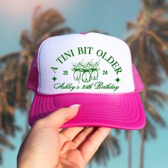 a pink and white trucker hat with the words tin bit older on it