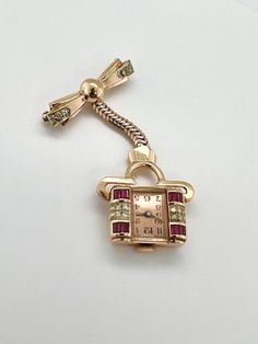 "A one of a kind mid-century piece with a story!  This solid 14k rose gold timepiece was made to be worn pinned on a nurse's lapel, so they can flip it and see the time, so the watch face hangs upside down when worn.  Adorned with custom cut ruby baguettes, and prong set diamonds on the watchface and pin component.  The original script engraving is still intact on the back of the watch reading \"Geoff to Theresa\".  This is an amazing vintage piece to add to any collection, it is as unique as it is beautiful." Mid-century Yellow Gold Brooch Jewelry, Mid-century Yellow Gold Brooch, Vintage Rose Gold Jewelry For Evening, Rose Gold Vintage Jewelry For Evening, Art Deco Yellow Gold Jewelry And Watches For Gift, Timeless Jewelry Brooch As Gift, Timeless Jewelry Brooch For Gift, Timeless Gift Jewelry Brooch, Luxury Rose Gold Brooch Jewelry