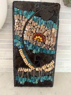 a mosaic tile wall hanging in a bathroom