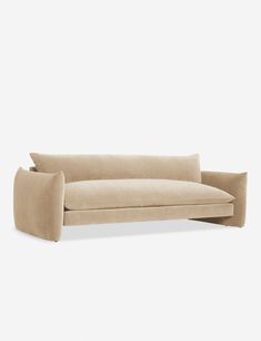 a beige couch sitting on top of a white floor