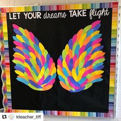 a bulletin board with an image of colorful wings and the words let your dreams take flight