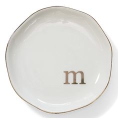 a white plate with the letter m on it's side and brown trim around the edge