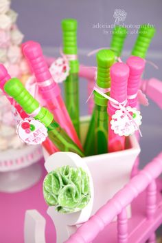 there are many pink and green toothbrushes in the cup on the table,