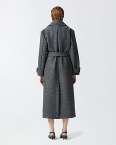 Women's long double-breasted coat made from yarn-dyed wool-blend twill cloth. The silhouette—which includes a lapel collar, long sleeves with cuff tab and matching-fabric waist belt—is inspired by the classic trench coat. Slanted side pockets and double-breasted button fastening. Office Wool Coat With Belted Cuffs For Fall, Fall Wool Coat With Belted Cuffs For Office, Fall Office Wool Coat With Belted Cuffs, Tailored Belted Wool Coat For Winter, Winter Wool Coat With Belted Cuffs For Work, Fall Wool Coat With Belted Cuffs And Lapel Collar, Formal Fall Pea Coat With Belted Cuffs, Classic Wool Coat With Belted Cuffs For Fall, Wool Coat With Belted Cuffs For Spring