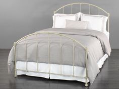 a white metal bed with two pillows on it