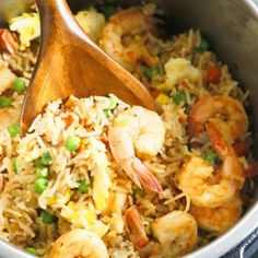 shrimp and rice in a pot with a wooden spoon