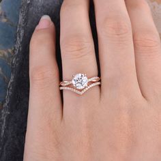 a woman's hand with two engagement rings on it