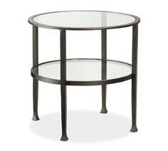 a round glass table with metal legs and a shelf on the bottom that holds two shelves